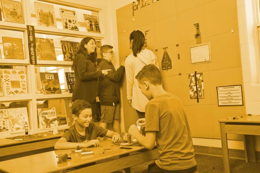 This is an image of students working at a lego wall
